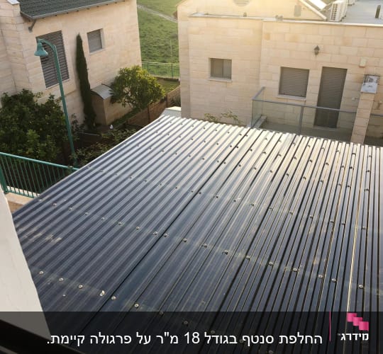 גג מתכת עם ברגים, עצים ברקע